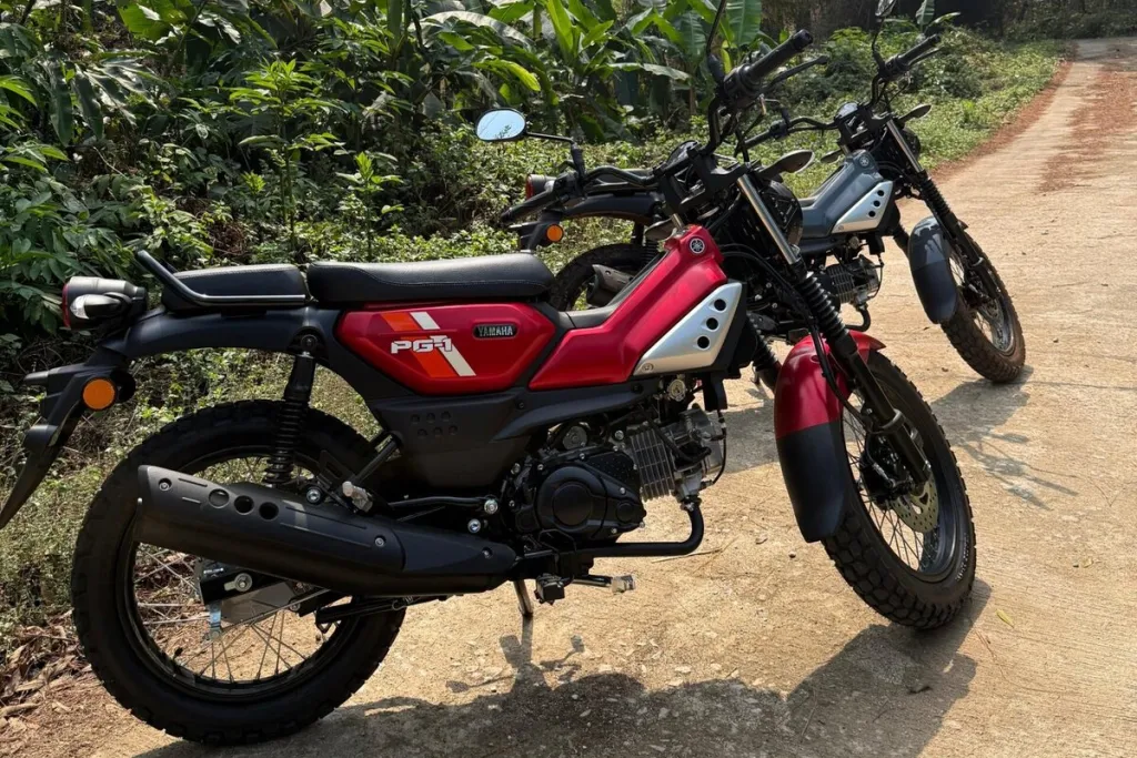 Two Yamaha PG-1 motorbikes on a dirt track in the jungle